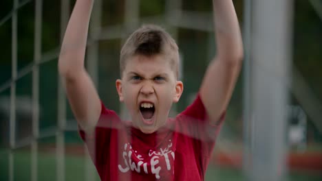 Portrait-of-a-child-in-a-red-t-shirt-celebrating-a-goal