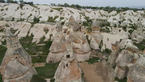 Aerial-backward-moving-shot-of-rocky-landscape-with-unusual-rock-formation-called-fairy-chimneys-in-Goreme,Cappadocia,-Turkey