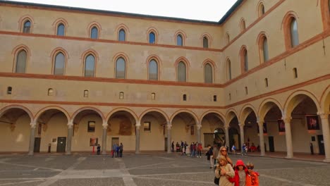 Family-posing-for-photo-at-Castello-Sforzesco-or-Sforza-castle-courtyard-in-Milan,-Italy