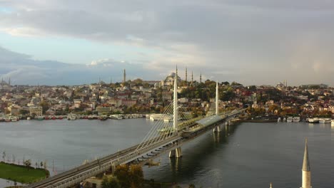 Luftdrohne-Eines-Bewölkten-Sonnenaufgangsmorgens-In-Istanbul,-Türkei,-Während-Möwen-über-Die-Halic-U-Bahn-Brücke-Und-Den-Bosporus-Fliegen