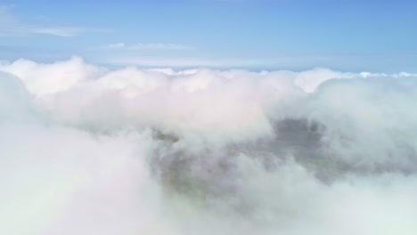 Desciende-El-Vuelo-Aéreo-De-Drones-A-Través-De-Nubes-Blancas-Que-Revelan-Campos-Verdes-En-El-Valle