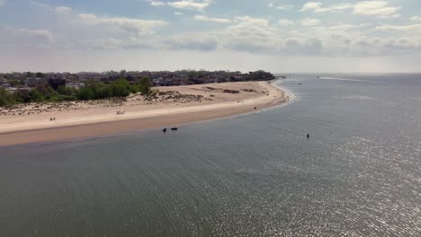 An-aerial-view-of-the-beach-on-Gravesend-Bay-Brooklyn,-NY-on-a-beautiful-day-with-blue-skies-and-white-clouds