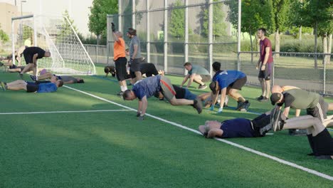 Men-exercising-on-a-soccer-field-in-the-morning