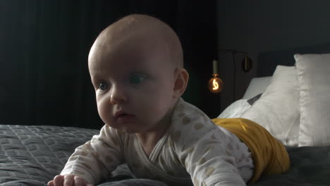 Isolated-cute-caucasian-Baby-on-black-blanket-in-dark-bedroom-Staring-Up,-close-shot