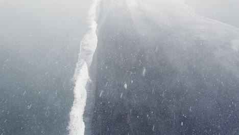 Schneesturm-über-Dem-Schwarzen-Sandstrand-Von-Hvalnes-In-Island,-Drohnen-Luftaufnahme-Aus-Einem-Hohen-Winkel