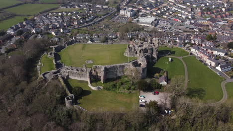 An-aerial-view-of-Denbigh-Castle-ruins-on-a-sunny-day,-flying-left-to-right-around-the-castle,-Denbighshire,-North-Wales,-UK