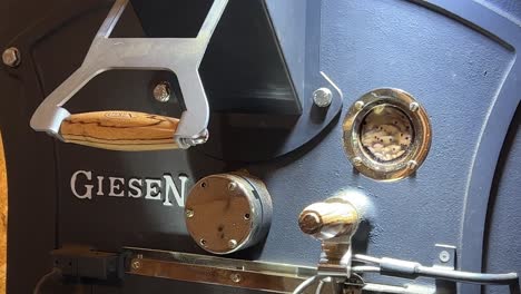 Speciality-coffee-production-warehouse,-close-up-shot-of-beans-roasting-in-the-giesen-machine-with-control-heat-level-and-necessary-monitor
