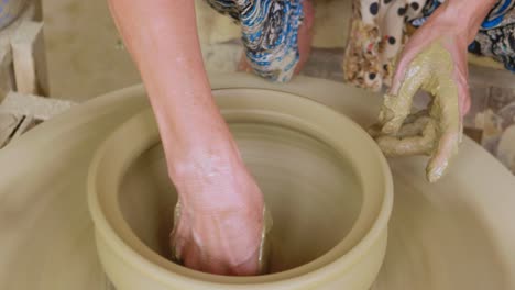 Finalizing-clay-pot-on-a-manual-potters-wheel-with-thread