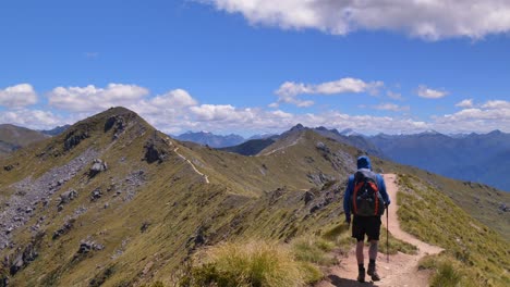 Static-off-center,-hiker-crosses-alpine-ridge,-vast-mountain-landscape,-Fiordland,-Kepler-Track-New-Zealand