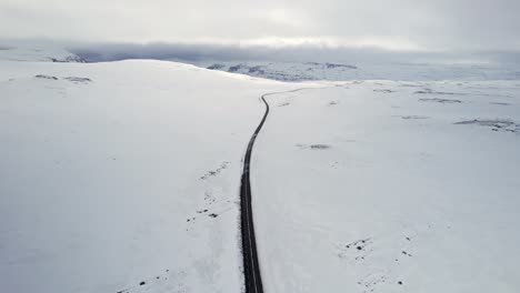 Road-in-the-middle-of-a-snow-covered-landscape-in-Iceland-wilderness