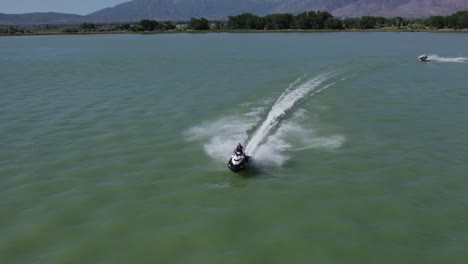 Man-ripping-over-Utah-Lake-with-a-jet-ski,-summertime-recreation