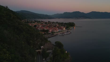 Flying-along-a-mountain-at-the-shore-of-Lake-Lago-Maggiore-in-Italy-and-Switzerland-seen-from-above-in-bird-view-by-aerial-drone