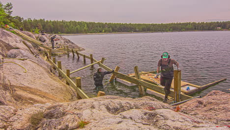 Timelapse-shot-of-workers-building-wooden-jetty-beside-blue-lake-on-a-summer-day-in-timelapse