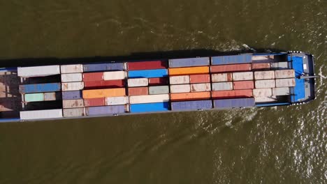 Aerial-Birds-Eye-View-Of-Missouri-Ship-Carrying-Shipping-Containers-Along-River-Noord