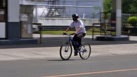 Anschauliches-Video,-Das-Eine-Person-Mit-Gesichtsmaske-Zeigt,-Die-Mit-Dem-Fahrrad-In-Der-Stadt-Cebu-Zur-Arbeit-Fährt.
