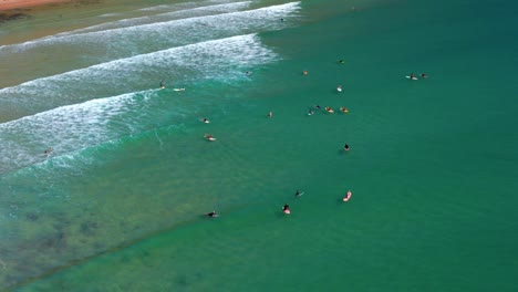 Tourists-Floating-With-Their-Surfboards-On-The-Beach-At-Noosa-National-Park-In-Queensland,-Australia