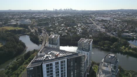 Aerial-drone-fly-over-the-high-rise-apartment-complexes-at-Wolli-Creek-suburb-with-Sydney-CBD-cityscape-in-the-background