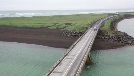 Island-Auto-Mit-Brücke-Am-Schwarzen-Strand