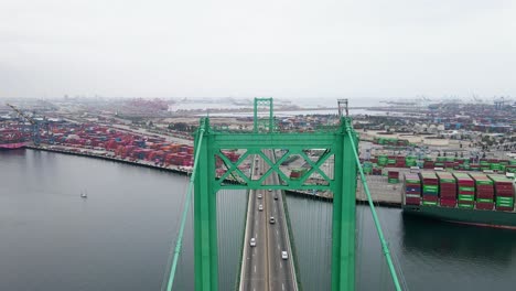 Aerial-view-over-traffic-on-the-Vincent-Thomas-Bridge,-in-cloudy-LA,-USA---reverse,-drone-shot