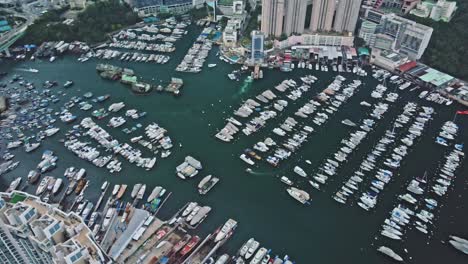 Panoramic-aerial-view-of-typhoon-shelter-made-with-hundreds-of-boats-in-Aberdeen,-Hong-Kong