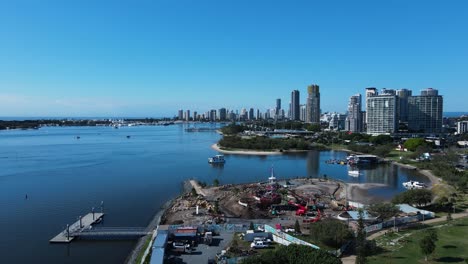 Construction-of-a-new-adventure-park-created-on-the-foreshore-with-a-city-skyline-backdrop-High-drone-view