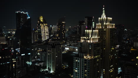 Bangkok-High-Raised-Buildingst,-Pan-Up-Massive-Skyline-at-Night,-Background-Bright-Light-in-the-Night,-Bangkok-Skyline-at-Night-with-Clear-Skies