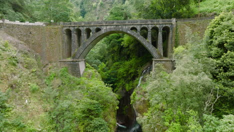 Old-arch-bridge-over-ravine-in-Madeira-interior,-A-Ponte-Velha