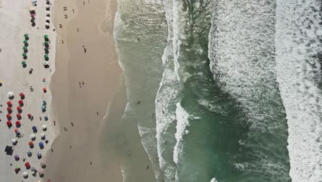 Aerial-top-down-view-of-Praia-Do-Forte,-Cabo-Frio,-Brazil-during-spring-break