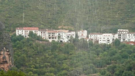 Slow-motion-shot-of-rain-falling-with-the-old-Spanish-mountain-village-of-Chulilla-in-the-background