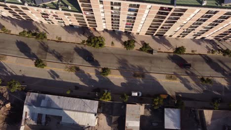 Aerial-overhead-tracking-shot-of-cars-driving-on-road-at-Chacarita-Area-in-Buenos-Aires-during-sunset