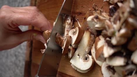 Vertikale-Aufnahme-Von-Händen,-Die-Portobello-Pilze-Mit-Einem-Küchenmesser-Schneiden