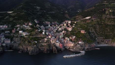 Aerial-arc-of-Riomaggiore-colorful-houses-on-terraced-hillside,-Italy