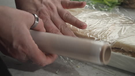 Smorgastarta,-Scandinavian-sandwich-cake,-is-covered-with-plastic-wrap
