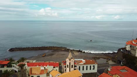Drone-Sobre-El-Extremo-De-La-Playa-Del-Sol-Con-Cielo-Azul-Y-Mar-De-La-Isla-De-Madeira