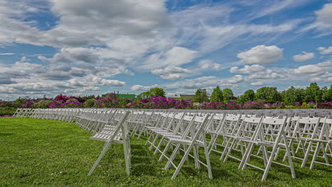 Clouds-Moving-Over-Rows-Of-Empty-Wooden-White-Chairs