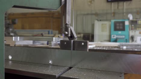 Aluminum-Plate-Being-Cut-On-A-Industrial-Bandsaw-In-A-Metal-Workshop