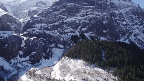 Luftaufnahmen,-Die-über-Eine-Verschneite-Gletscherlandschaft-über-Einen-Fluss-In-Richtung-Großer-Kalksteinfelsen-Fliegen