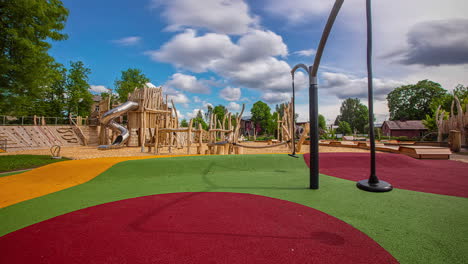 Static-shot-of-colorful-playground-floor-along-with-wooden-play-equipment-in-an-outdoor-playground-at-daytime-in-timelapse