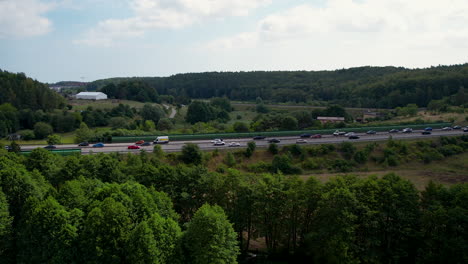 Panorama-view-of-traffic-on-freeway-in-Poland-with-green-trees-and-hills-in-nature
