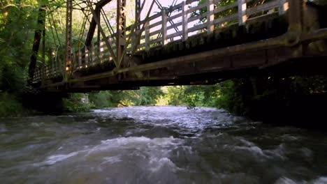 aerial-push-up-river-and-under-bridge-in-damascus-virginia