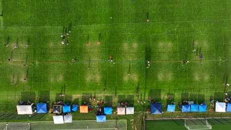 Top-down-aerial-truck-shot-of-worn-volleyball-courts-at-grass-tournament