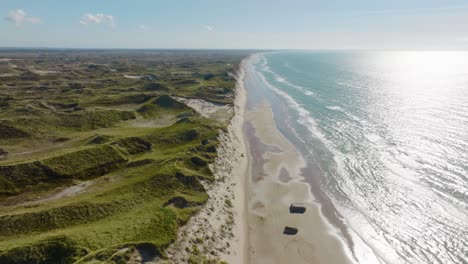 Panoramic-view,-sand-dunes,-the-World-War-II-bunkers-on-a-beach,-and-views-of-the-North-Sea