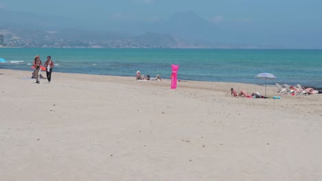 Menschen-Sonnen-Sich,-Während-Sie-Am-Strand-Am-Ufer-Des-Mittelmeers-In-Alicante,-Spanien,-Liegen