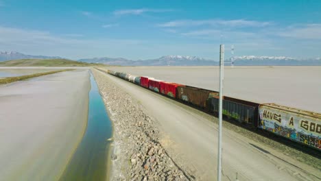 AERIAL---Train-on-railway,-Great-Salt-Lake,-Utah,-forward-truck-right-shot