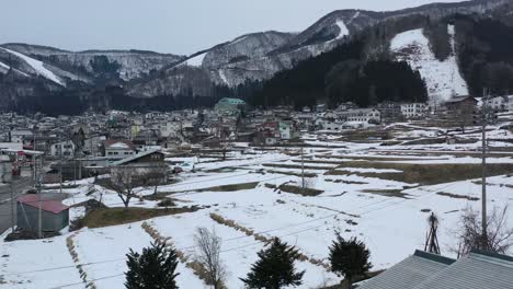 Nieve-Derritiéndose-En-La-Estación-De-Esquí-Nozawa-Onsen-De-Nagano-Japón-Durante-El-Invierno,-Antena