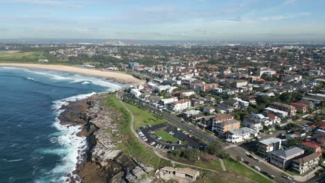 Aerial-static-over-Maroubra-Beach,-suburban-residential-housing-with-park-and-streets-in-Sydney,-NSW-Australia