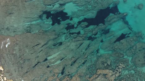 aerial-shot-of-crystal-clear-blue-water-near-one-of-Sardinia-island-beaches