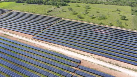 Disparo-De-Drones-Panorámico-Sobre-Filas-De-Paneles-Solares-Que-Aprovechan-La-Energía-Solar-Para-Energía-Renovable-En-El-Desarrollo-Del-Parque-Fotovoltaico-El-Soco,-República-Dominicana