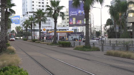Casablanca-electric-tramway-arriving-from-the-front-on-Abdelmoumen-boulevard,-Palm-trees