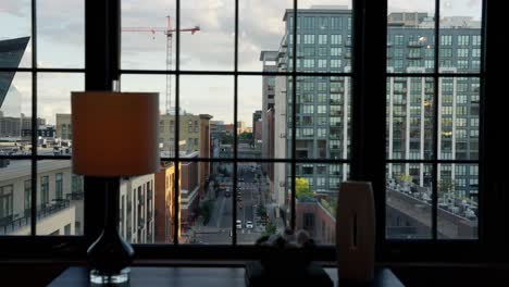 push-in-shot-shot-of-city-street-through-the-windows-of-an-apartment-building-downtown
